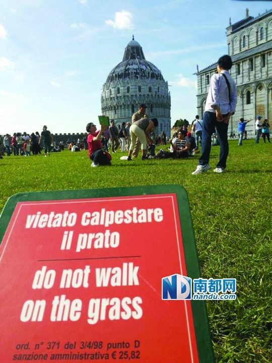 中国游客无视警示在意大利比萨斜塔前草坪席地开餐